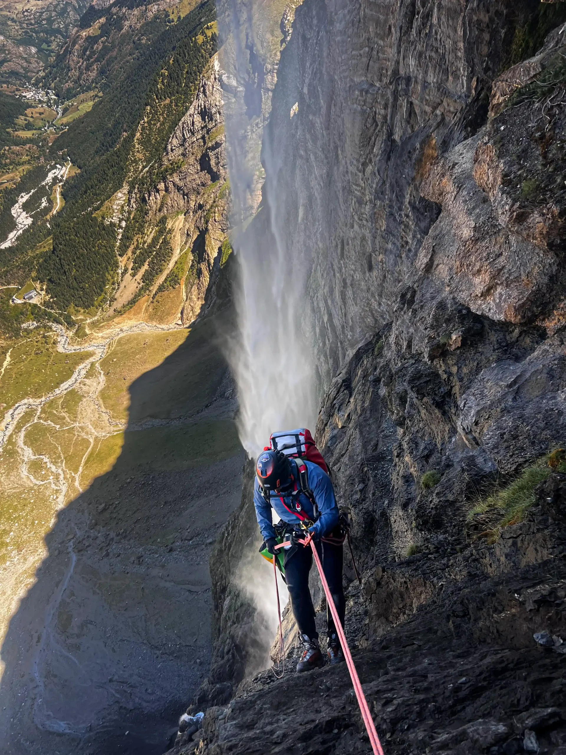 Descending a rope through the spray of a canyon waterfall